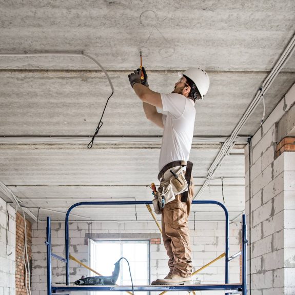 Electrician Working With Cable On Construction Site